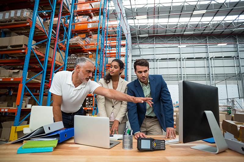 Warehouse managers and worker discussing with computer Warehouse Managers
