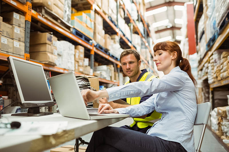Warehouse worker and manager looking at laptop Warehouse Management